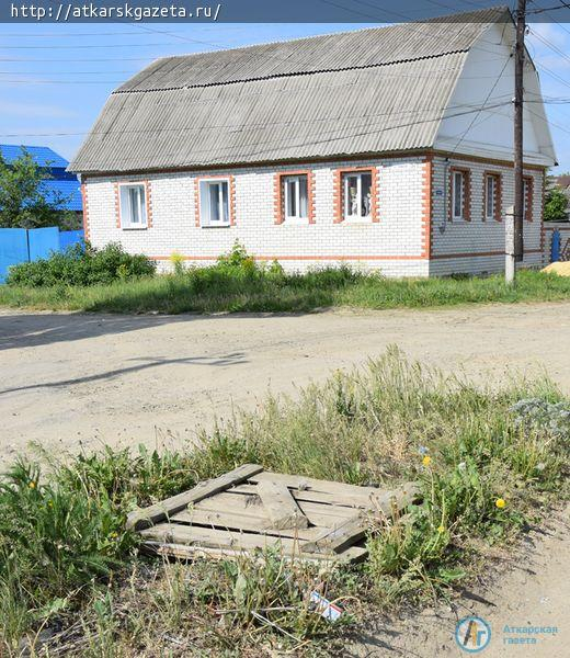 Люк рядом со школой №10 прикрыт старыми досками и ржавым железом